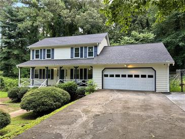 Charming two-story home with a front porch, attached garage and well-manicured landscaping at 460 Heathrow Way, Stone Mountain, GA 30087