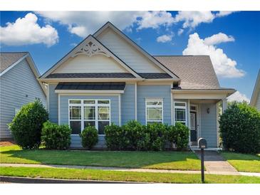 Charming blue home featuring manicured landscaping, a covered front porch, and decorative gable detailing at 903 Duncan Ter, Canton, GA 30115