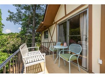 Relaxing balcony with seating provides a cozy outdoor living space with lush green tree views at 1225 Church St # M, Decatur, GA 30030