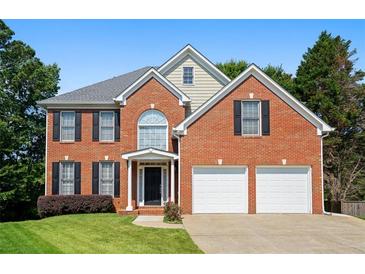 Charming brick two-story home with black shutters, a well-manicured lawn, and a two car garage at 3053 Ramsey Pl, Marietta, GA 30062