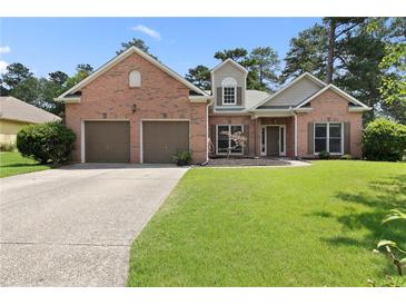 Charming brick home featuring a well-manicured lawn and an attached two-car garage at 3011 Stillwater Dr, Villa Rica, GA 30180