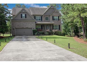 Charming two-story brick home featuring an attached two-car garage and mature landscaping at 3015 Guardian Nw Walk, Kennesaw, GA 30152