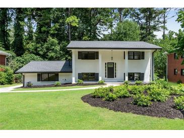 Charming two-story home featuring black window shutters, a landscaped yard, and a well-manicured lawn at 2550 Laurel Ridge Dr, Decatur, GA 30033