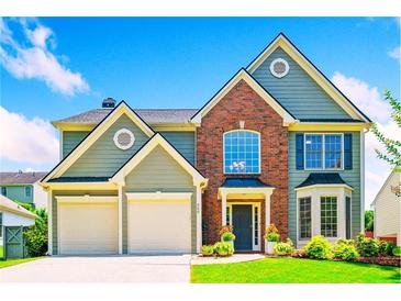 Charming two-story home with a well-manicured lawn, an attached two-car garage, and a beautiful brick facade at 560 Edgehill Pl, Johns Creek, GA 30022
