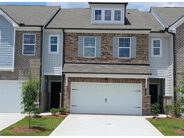 Charming townhome featuring a two-car garage, brick accents, and well-maintained landscaping at 545 Tuskegee St # 50, Mcdonough, GA 30252