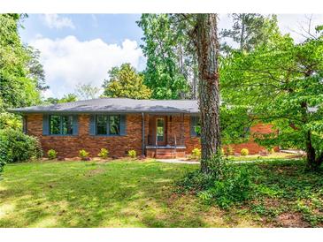 Charming brick home with a well-manicured lawn and mature trees at 3219 W Manor Ln, Atlanta, GA 30311