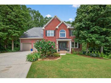 Charming two-story red brick home with black shutters, lush landscaping, and a well-manicured lawn at 505 Armor Knl, Powder Springs, GA 30127