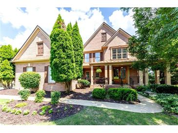 Charming brick home with a beautifully landscaped front yard and covered porch at 5347 Harbury Cv, Suwanee, GA 30024