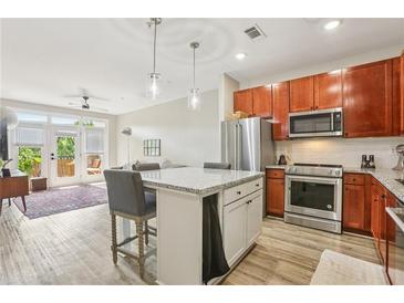 Bright kitchen features stainless steel appliances, granite counters, and an island with bar seating at 840 United Se Ave # 205, Atlanta, GA 30312