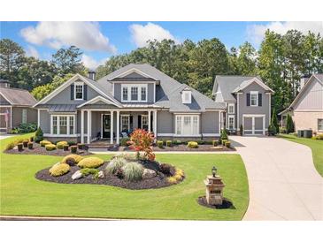 Charming home featuring professionally landscaped front yard with lush green grass and flower bed at 4875 Churchill Ridge Dr, Cumming, GA 30028