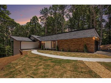 Beautiful exterior elevation with stone and manicured lawn at 9025 Huntcliff Trce, Atlanta, GA 30350