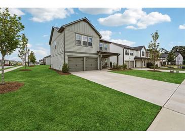 Charming two-story home with a well-manicured lawn and a two-car garage at 1001 Starmoss Ln, Conyers, GA 30094