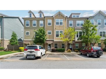 Exterior shot of a three-story townhome with a parking lot and partial green space at 2161 Colvin Ct, Atlanta, GA 30318