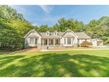 Charming single-story home featuring a symmetrical facade, bay windows, and a well-manicured lawn at 4120 Grady Smith Rd, Loganville, GA 30052