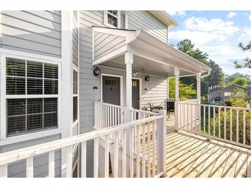 Inviting front porch featuring white railings, gray siding and doors and a peaceful, shaded sitting area at 4140 Riverlook Parkway Se Se Pkwy # 209, Marietta, GA 30067