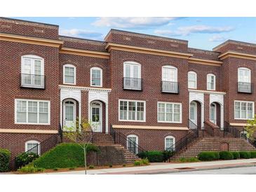 Charming brick townhomes feature front steps, petite balconies, and manicured landscaping at 5139 Peachtree Road, Chamblee, GA 30341