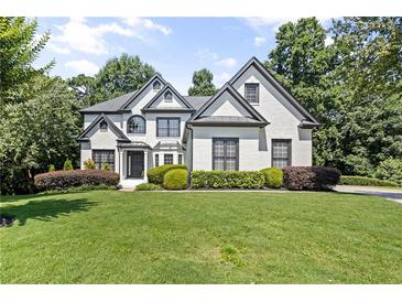 Charming two-story home showcasing a manicured lawn and well-maintained landscaping at 135 Emerald Ln, Roswell, GA 30075