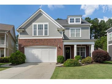 Charming two-story home boasts a brick and gray facade, complemented by a well-manicured lawn and a two-car garage at 6430 Banbury Se Ct, Mableton, GA 30126
