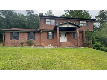 Charming two-story brick home with covered front porch and a lush green lawn at 1095 Mitchell Crossing Sw Dr, Atlanta, GA 30331
