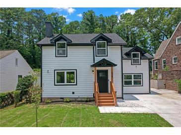 Inviting two-story home with white siding, black trim, dormer windows, and a well-manicured front lawn at 656 S Elizabeth Nw Pl, Atlanta, GA 30318