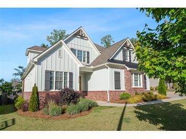 Charming two-story home with brick accents, gray siding, and meticulously manicured landscaping at 2208 Sage Mountain Sw Ct, Marietta, GA 30064