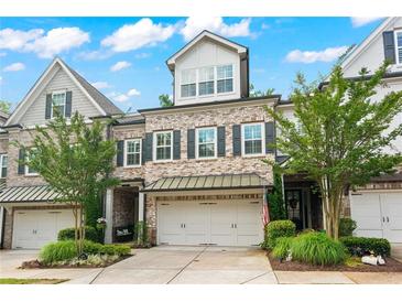 Charming townhome with brick facade, two-car garage, landscaped front yard, and mature trees at 4486 Huffman Drive Ne Dr, Roswell, GA 30075