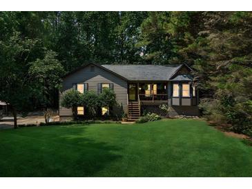 Charming home featuring a lush green lawn and inviting screened in front porch perfect for relaxing outdoors at 202 Cedar Valley Ct, Canton, GA 30115