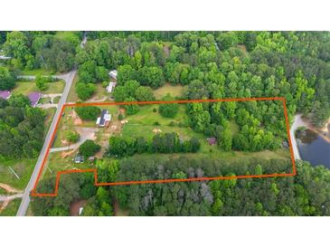 Expansive aerial view of a verdant, wooded property with lake access and an orange border line at 901 N Van Wert N Rd, Villa Rica, GA 30180