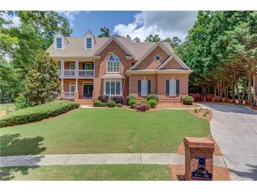Beautiful two-story brick home with manicured lawn and covered front porch at 2748 Hidden Falls Dr, Buford, GA 30519