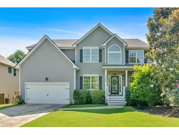 Charming two-story home featuring a well-manicured lawn, a two-car garage and beautiful front yard landscaping at 290 Prescott Dr, Acworth, GA 30101