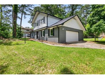 Charming two-story home featuring a gray brick exterior and well-maintained lawn at 5058 Rock Springs Rd, Lithonia, GA 30038
