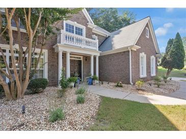 Charming brick home featuring a quaint front porch with white columns and well-manicured landscaping at 3123 Wolf Club Dr. Sw, Atlanta, GA 30349