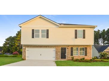 Charming two-story home featuring a brick facade, attached garage, and well-maintained lawn at 45 Chimney Ridge Ln, Covington, GA 30014