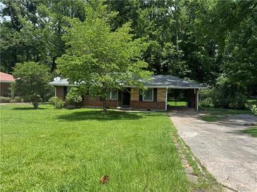 Charming brick home with a lush green front yard and a covered carport providing convenient parking at 2014 Brannen Se Rd, Atlanta, GA 30316