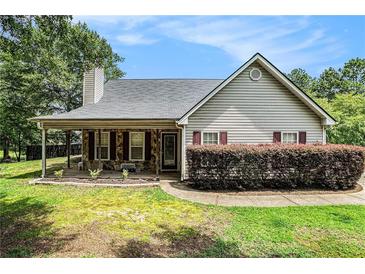 Charming home featuring a covered front porch and stone accents enhancing its curb appeal at 55 Ashland Farm Rd, Oxford, GA 30054