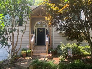 Charming front door with wooden steps and decorative wreath, surrounded by lush landscaping at 227 Bennett Farms Trl, Acworth, GA 30102