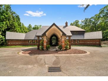 Stunning front view of home featuring circular drive, portico entrance, and lush landscaping at 114 Lees Lake Rd, Fayetteville, GA 30214