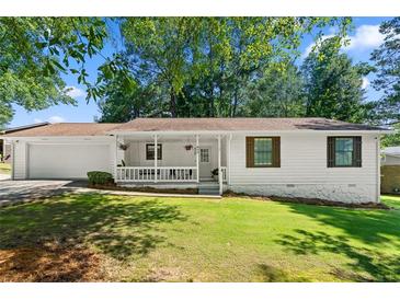 Charming single-story home with a covered porch and well-maintained lawn at 830 The Cir, Lawrenceville, GA 30043