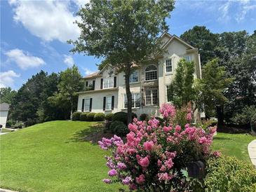 Charming two-story home featuring lush landscaping, a manicured lawn, and mature trees, creating inviting curb appeal at 600 Oakmont Hl, Duluth, GA 30097