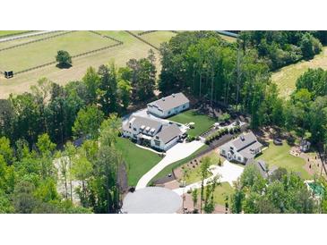Stunning aerial view of estate home, guest house, horse barn, pool, and well landscaped grounds at 604 Trinity Church Rd, Canton, GA 30115