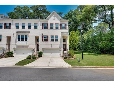 Charming townhome with white brick facade, attached garage, and well-manicured lawn at 1823 Lynwood Ln, Atlanta, GA 30329