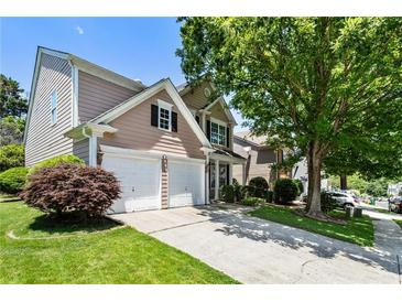 Charming home featuring a two-car garage, well-maintained lawn, and mature trees in a desirable neighborhood at 424 Citronelle Dr, Woodstock, GA 30188