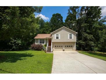 Charming two-story home featuring a two-car garage, red front door, and a well-maintained lawn surrounded by mature trees at 177 Rustin Dr, Dallas, GA 30157