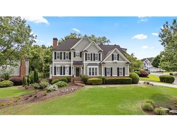 Charming two-story home boasts lush front lawn and mature landscaping at 295 Sagamore Nw Cv, Sugar Hill, GA 30518