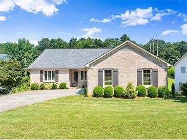 Charming brick home featuring a well-manicured front yard and gray shutters at 3260 Governors Court Ct, Duluth, GA 30096