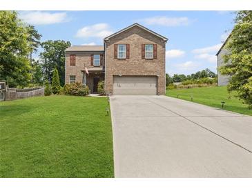 Inviting two-story brick home with a well-manicured lawn and a spacious driveway at 8553 Braylen Manor Dr, Douglasville, GA 30134