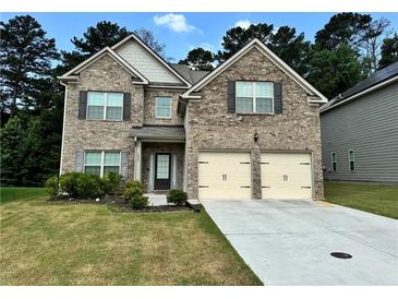 Charming brick two-story home with a manicured lawn and a two-car garage at 7487 Rudder Cir, Fairburn, GA 30213