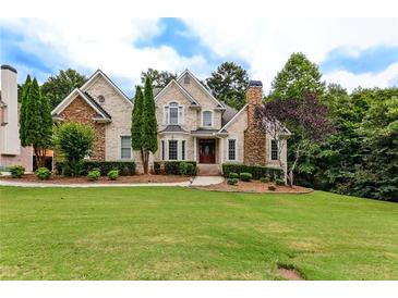 Beautiful two-story home with stone and brick facade, manicured lawn, and mature trees creating an inviting curb appeal at 1360 Mount Mickinley Dr, Grayson, GA 30017