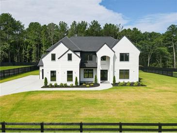 Stunning two-story home with a modern black and white exterior and a perfectly manicured lawn at 3207 Bold Springs Rd, Dacula, GA 30019