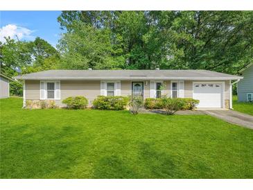 Charming one-story home with a well-manicured lawn and lush landscaping at 2454 Fairway Sw Cir, Atlanta, GA 30331
